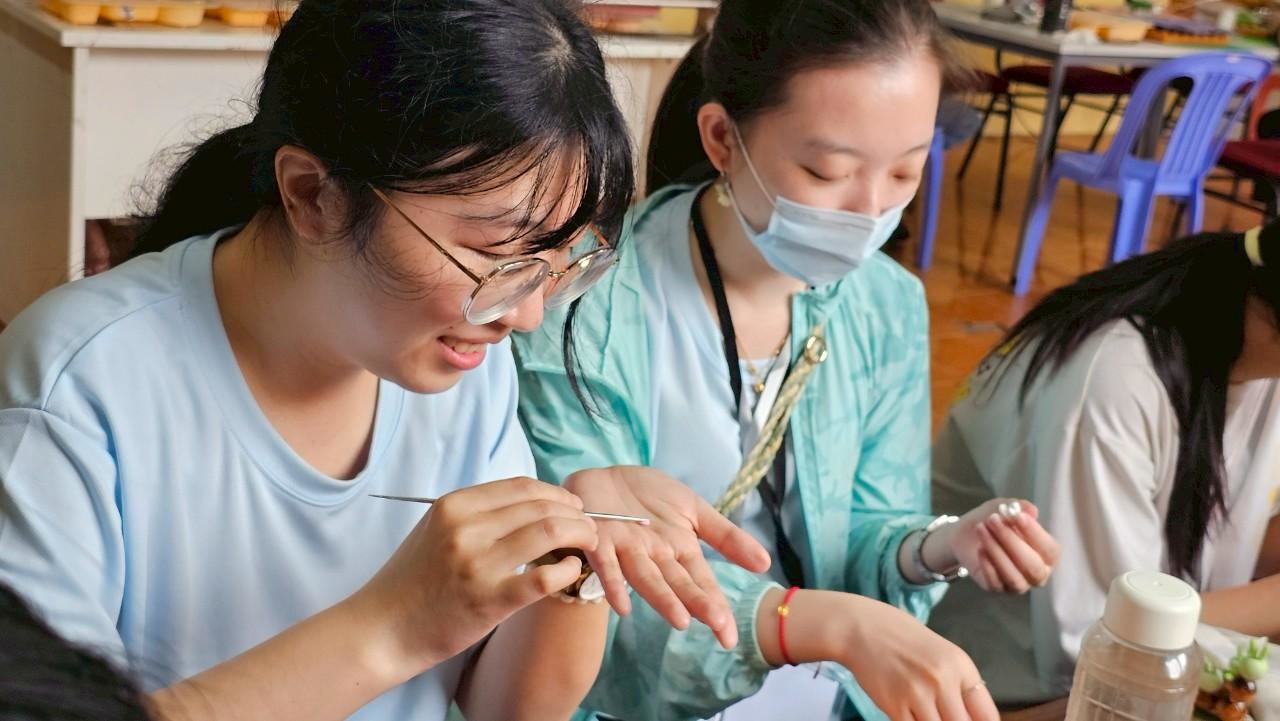 相關圖片 越南團志工與當地身障學生一同創作捏花作品。